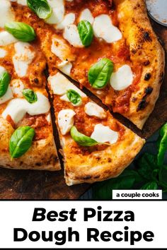 a pizza with mozzarella, basil and cheese on a wooden cutting board next to fresh basil leaves