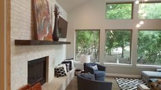 a living room filled with furniture and windows next to a fire place in front of a flat screen tv