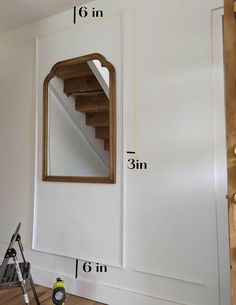 a room with white walls and wooden stairs