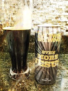 a can of beer sitting on top of a counter next to a glass filled with liquid