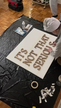 a man that is standing in front of a sign with scissors and tape on it