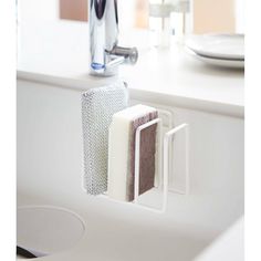 a bathroom sink with two soaps and a toothbrush holder