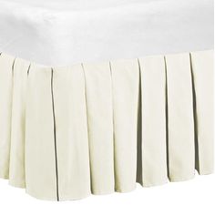 a white bed skirt with pleated edges