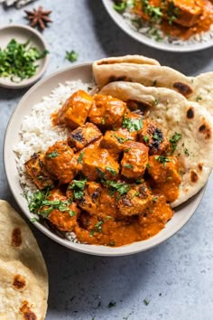 chicken tikka served over rice with pita bread on the side and garnished with parsley