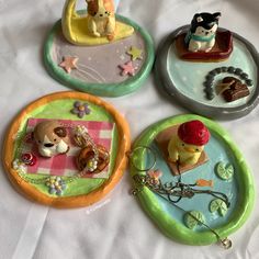 four plates with small figurines on them