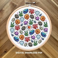 a cross stitch pattern in the shape of a circle with flowers and leaves on it