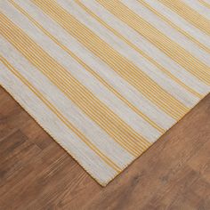 yellow and white striped rug on wooden floor