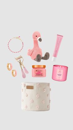 the contents of a pink flamingo gift set on a white background with gold accessories