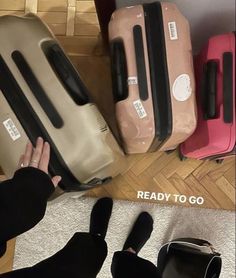 several suitcases are lined up on the floor and someone is holding their hand out