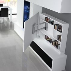 an open book shelf in the middle of a room with white walls and flooring