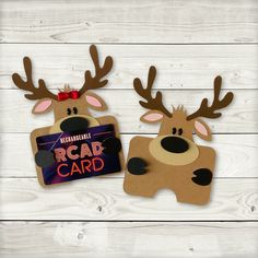 two cardboard reindeers with antlers on their heads holding a sign that says road card