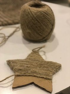 two balls of yarn are sitting on a table next to a star ornament