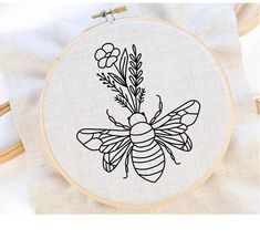 a cross stitch bee with flowers on it's back is shown in black and white