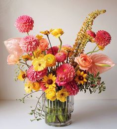 a vase filled with lots of different colored flowers