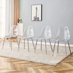 three clear chairs sitting on top of a rug in front of a wall with a guitar