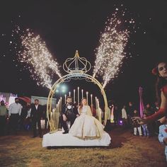 a bride and groom are sitting on a bed with fireworks in the sky behind them