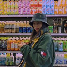 a woman standing in front of a store filled with drinks