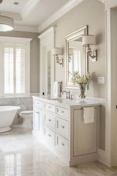 a white bathroom with marble floors and walls