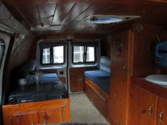 the inside of an rv with wood paneling and blue bedspread on it