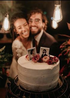 a man and woman standing next to a cake with pictures on it in front of them