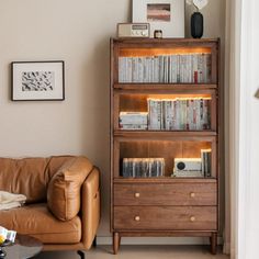 a living room with a leather couch and bookcase