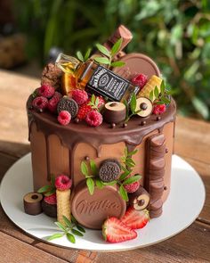 a chocolate cake decorated with raspberries, strawberries and other toppings on a plate