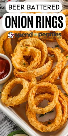 onion rings on a plate with ketchup and dipping sauce in the background text reads beer battered onion rings