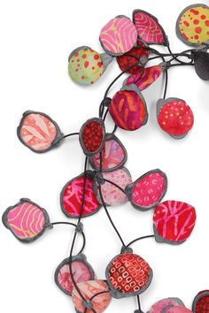 a bunch of colorful glass hearts hanging from a wire