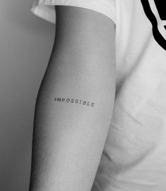 a man's arm with the word impossible written on it in black and white