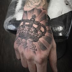 a man's hand with a crown tattoo on it