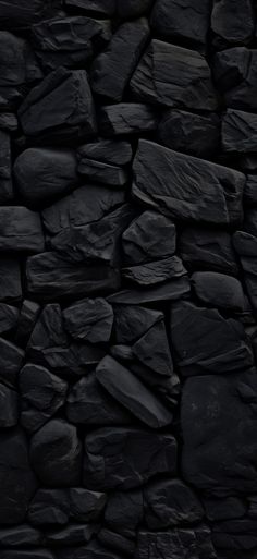 a black rock wall with lots of rocks on it