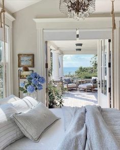 a bed sitting in a bedroom under a chandelier next to an open door