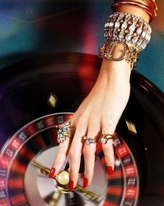 a woman's hand on top of a roule with gold rings and bracelets