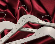 two white wooden hangers with the word bride written on them