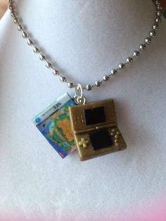 a necklace with a gameboy design on it and a ball chain attached to it