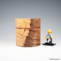 a small toy figure next to a wooden container