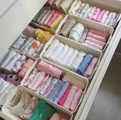 an organized drawer filled with lots of baby clothes