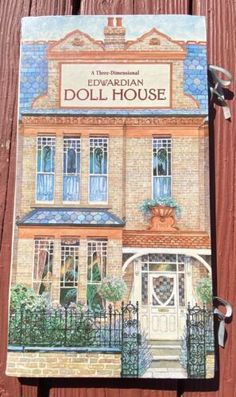 the front cover of a book with an image of a doll house on it's side