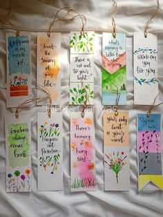 handmade bookmarks hanging from twine strings on a sheet of white paper with words written in different colors