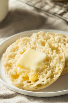 two biscuits on a white plate with butter