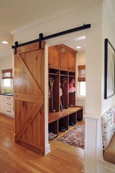 an open barn door in the entry way to a living room with wood flooring