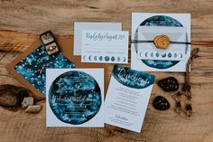 the wedding stationery is laid out on a wooden table