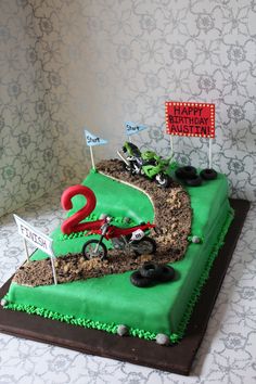 a birthday cake that is shaped like a dirt bike race track and number two on top