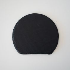 a round black object sitting on top of a white surface