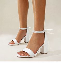 a woman wearing white high heel sandals