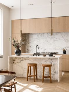 a kitchen with marble counter tops and wooden stools