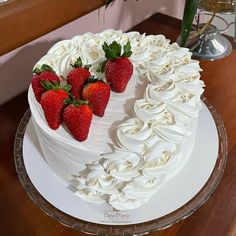 a cake with white frosting and strawberries on top