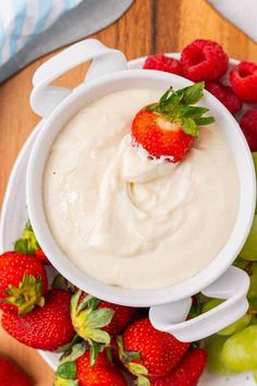 a white bowl filled with cream and strawberries