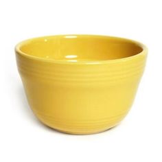 a yellow bowl sitting on top of a white table