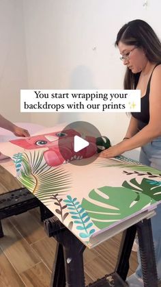 two women working on an art project with the words you start wrapping your backdrops with our prints